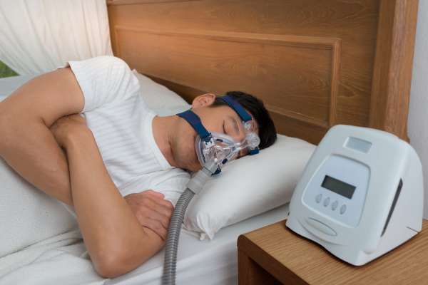 man sleeping with CPAP machine