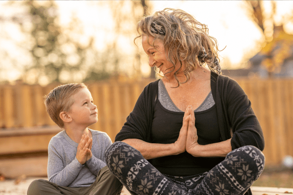 Grandmother performing yoga with grandson