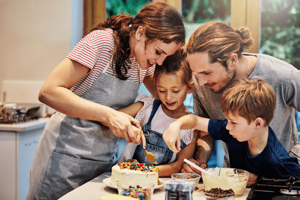 Family decorating a cake