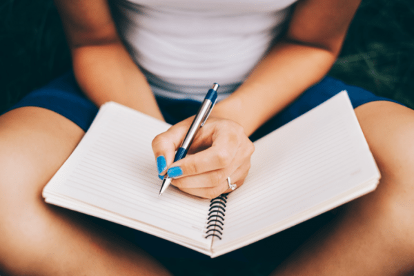 person writing in journal