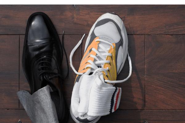 Dress shoe next to a sneaker